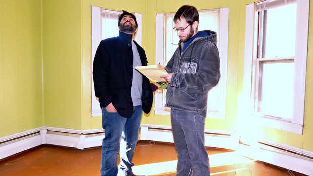Craig Saddlemire and Shaad Masood inspect a third-floor bedroom in the building recently purchased by the newly formed Raise Op housing cooperative. Photo by Sun Journal.